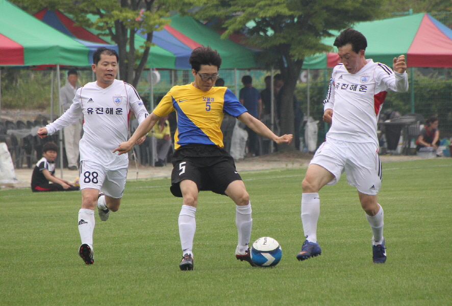 부산 향우팀(하얀색 유니폼)과 거제 향우팀이 향우초청친선축구대회에서 경기를 펼치고 있다.